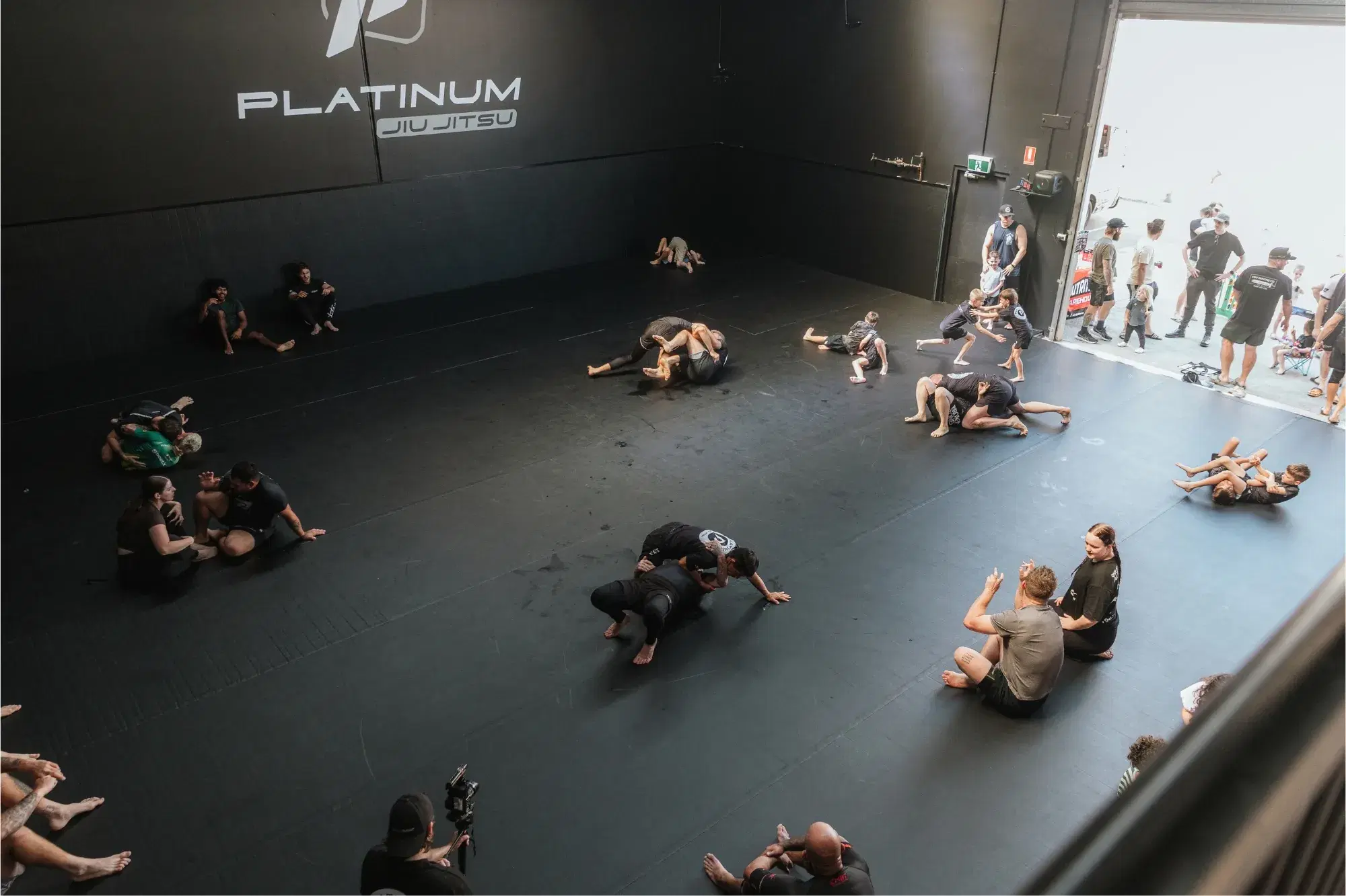 Kids and adults training jiu-jitsu on the mats at the Platinum Jiu Jitsu open day in Oxenford, Gold Coast