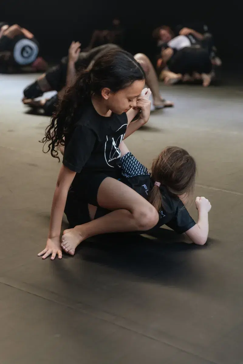 Two young girls practising jiu-jitsu in the kids class at Platinum Jiu Jitsu Oxenford